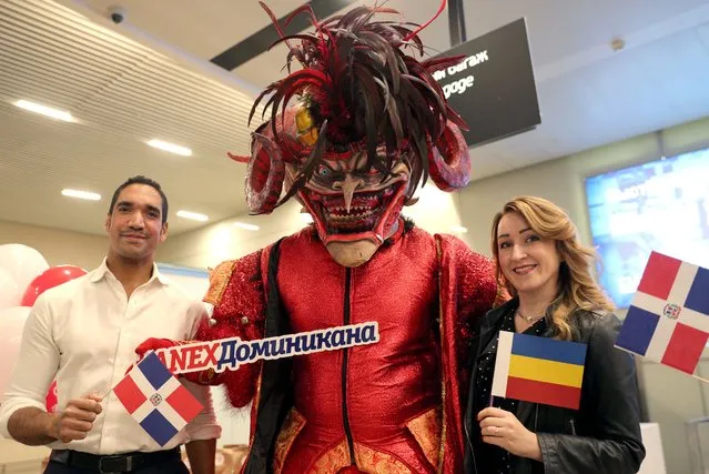 Anex Tour travel agency workers and a costumed character pose for a photograph as travellers check in for a flight to Punta Cana, Dominican Republic, at the Platov International Airport in Rostov-On-Don Region, Russia on October 10, 2021. Azur Air has begun operating flights between Russia and the Dominican Republic once in 11 days. Russia suspended most direct international flights in March 2020 in connection with the COVID-19 pandemic. In early August 2021, Russia completely removed the ban on direct flights to the Dominican Republic. (Photo by Erik Romanenko/TASS)