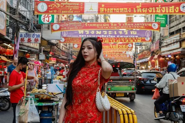 A woman poses for a picture during Lunar New Year's Eve on Yaowarat Road in Bangkok's Chinatown, Thailand, February 9, 2024. (Photo by Jorge Silva/Reuters)