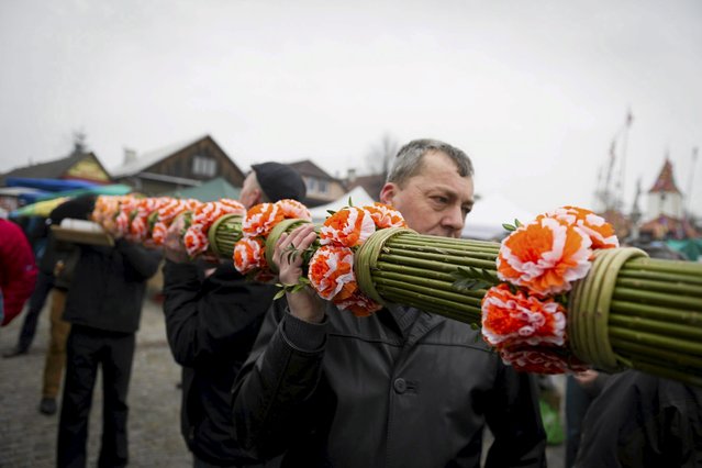 A man holds traditional palm, made of wicker twigs and decorated with colourful flowers and ribbons are pictured during the Catholic Palm Sunday procession and traditional contest for the largest handmade palm in Lipnica Murowana near Krakow, southern Poland, March 20, 2016. (Photo by Lukasz Krajewski/Reuters/Agencja Gazeta)