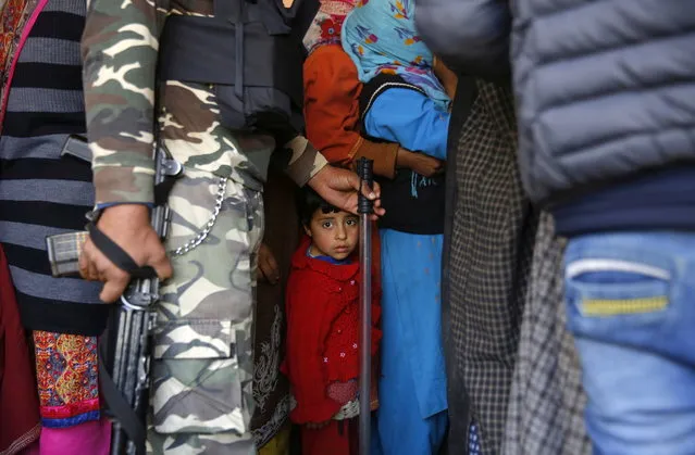 A child looks on as Kashmiri voters wait in a queue to cast their votes at a polling station in Mujgund on the outskirts of Srinagar, the summer capital of Indian Kashmir, 18 April 2019. Voting begins in 95 Seats across 11 States in second phase of parliamentary or general elections for India's 545-member lower house of parliament, or Lok Sabha, that is held every five years. The parliamentary elections, which began on 11 April 2019 are to be conducted in seven phases throughout India and result will be announced on 23 May. (Photo by Farooq Khan/EPA/EFE)