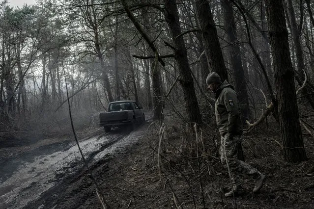 A Ukrainian soldier from a self-propelled artillery unit walks at a forest base near the frontline in Donetsk in the second decade of February 2024. (Photo by Kasia Stręk/The Observer)