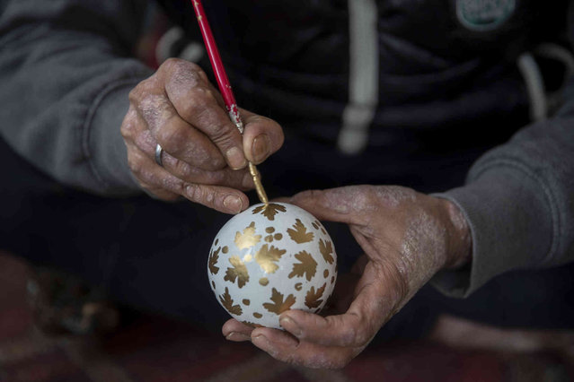 A Kashmiri artist paints Christmas-related papier-mache items at a workshop in Srinagar, Indian controlled Kashmir, Wednesday, November 3, 2021. Papier-mache was introduced in the region by Muslims from Persia in the 15th century. (Photo by Dar Yasin/AP Photo)