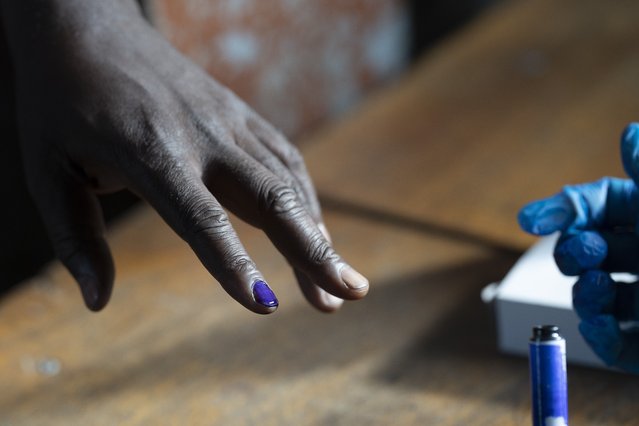 A man has his nail inked before casting his ballot for Gambia's presidential elections, in Banjul, Gambia, Saturday, December 4, 2021. (Photo by Leo Correa/AP Photo)