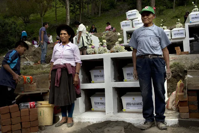 In this March 29, 2016 photo, Vicente Vicana Lapa, 65, right, and a relative pose for pictures next to coffins holding the remains of his slain wife, two daughters and son-in-law, all of whom were killed inside their village church more than two decades ago by Shining Path rebels, at a cemetery in Ccano, a village in the Huanta area of Ayachcuo department, Peru. "Alberto Fujimori brought peace. He was a good man; without him, the Shining Path would have killed us all,” said Vicana. Vicana worries that leftist insurgents could return if a weak leader were elected. (Photo by Rodrigo Abd/AP Photo)