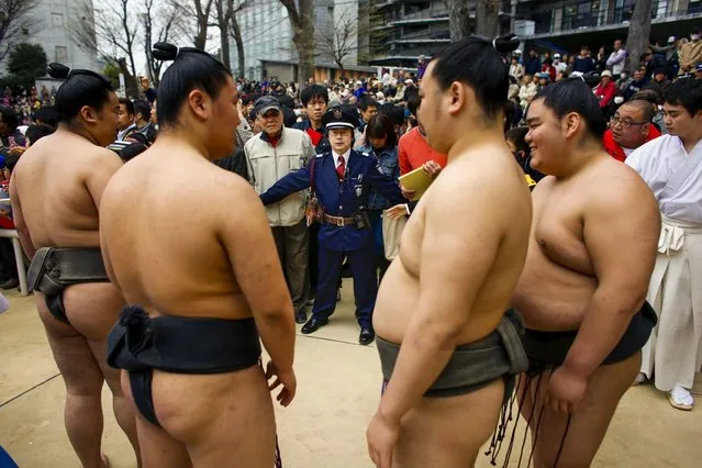 A police officer contains supporters as they watch the arrival of sumo wrestlers at the “Honozumo” ceremonial sumo tournament at the Yasukuni Shrine in Tokyo April 3, 2015. (Photo by Thomas Peter/Reuters)