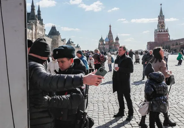 A police officer (2-L) checks a man at the entrance to the Red Square amid tighten security measures in the wake of a terrorist attack at the Crocus City Hall concert venue, in Moscow, Russia, 27 March 2024. (Photo by Yuri Kochetkov/EPA/EFE)