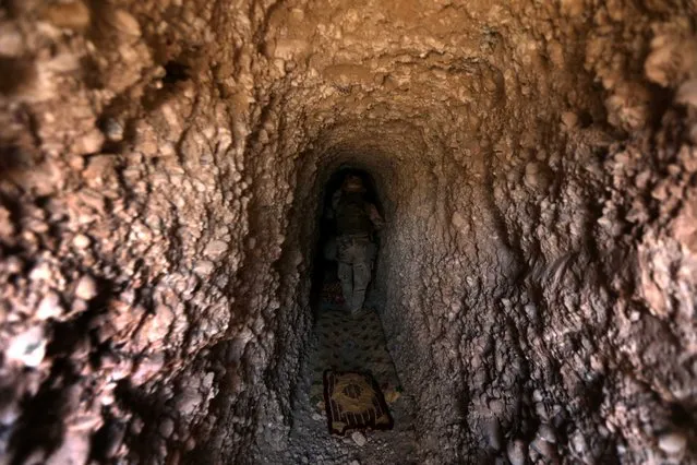 An Iraqi soldier inspects a tunnel as he holds a position on the frontline on April 9, 2016 in the town of Kharbardan, located 10 kilometres (6 miles) south of Qayyarah, during military operations to recapture the northern Nineveh province from Islamic State group's jihadists. Iraqi army troops and allied paramilitary fighters on March 24 launched a major offensive aimed at retaking the northern Nineveh province, the capital of which, Mosul, is the main hub of IS in Iraq. Qayyarah is about 60 kilometres (35 miles) south of Mosul. (Photo by Safin Hamed/AFP Photo)