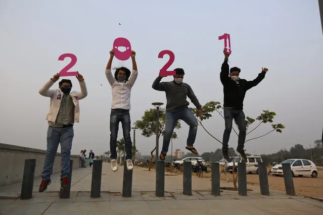 People hold cutouts to welcome the New Year in Ahmedabad, India, Thursday, December 31, 2020. (Photo by Ajit Solanki/AP Photo)