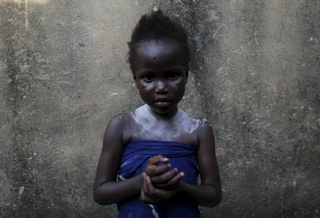 Mariam Tchinda, 6, stands at her home in Cocody Danga slum in Abidjan May 25, 2015. (Photo by Luc Gnago/Reuters)