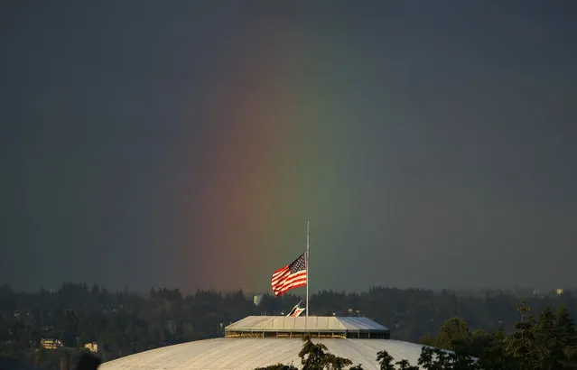 A rainbow appears behind the U.S. flag flying at half-staff on top of the Tacoma Dome, Monday, June 13, 2016, in Tacoma, Wash. Flags across the state were at half-staff Monday to honor the victims of a mass shooting early Sunday at a gay nightclub in Orlando, Florida. (Photo by Ted S. Warren/AP Photo)