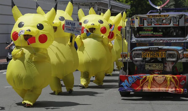 Environmental activists wearing Pikachu costumes hold a rally as a passenger jeepney passes by the Japanese embassy in Manila, Philippines on Tuesday, June 25, 2019. The group is challenging Japan to stop financing coal as it prepares to host the Group of 20 leaders summit. (Photo by Aaron Favila/AP Photo)