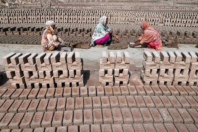 Women bake clay bricks at a kiln on the outskirts of Lahore on April 30, 2024. (Photo by Arif Ali/AFP Photo)