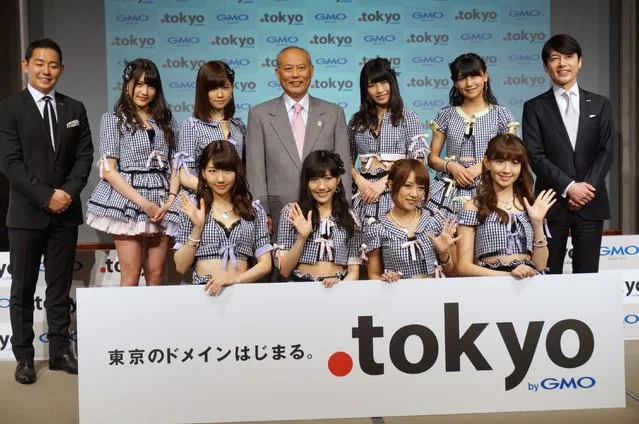 Tokyo Gov. Yoichi Masuzoe (back row, center), executives of GMO Registry Inc. (far left and far right), and members of idol group AKB48 attend a ceremony marking the debut of the Internet domain “.tokyo” at a Tokyo hotel on Monday, April 7, 2014. (Photo by Kazuaki Nagata)