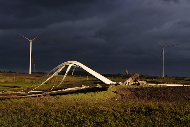 The remains of a tornado-damaged wind turbine touch the ground in a field, Tuesday, May 21, 2024, near Prescott, Iowa. (Photo by Charlie Neibergall/AP Photo)