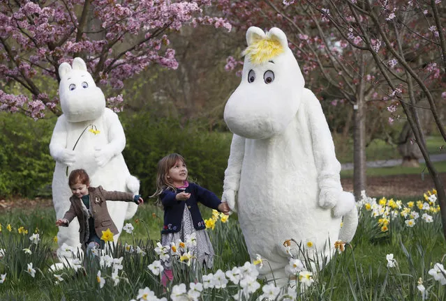 Sofia Lopez, right, and Eve Chick both 3 years old, meet Moominmamma, right, and Moomintroll, left, during a photo call for the Moomin Adventures at Kew Gardens Easter Festival at Royal Botanic Gardens, Kew in London, Thursday, March 30, 2017. The festival will run from April 1 until April 17, and will be an opportunity to experience the world of the Moomins with family-friendly activities and events. Moomins are fairy tale characters taken from the books of Finnish illustrator and writer Tove Jansson. (Photo by Kirsty Wigglesworth/AP Photo)