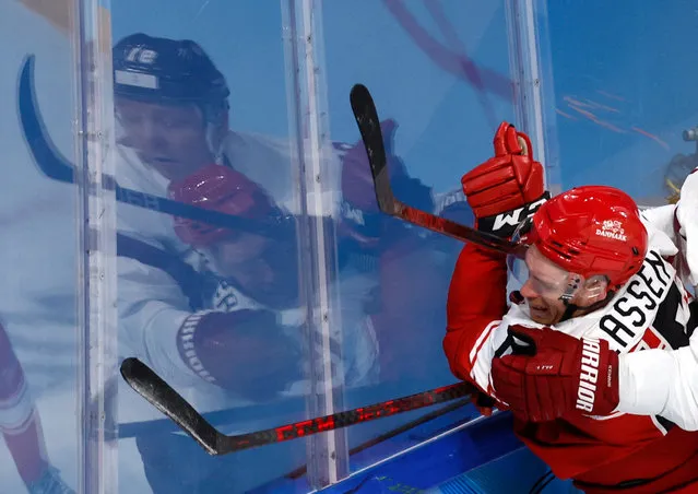 Denmark's Matias Lassen (15) and Latvia's Ronalds Kenins (91) collide during a men's qualification round hockey game at the 2022 Winter Olympics, Tuesday, Feb. 15, 2022, in Beijing. (Photo by Jonathan Ernst/Reuters)