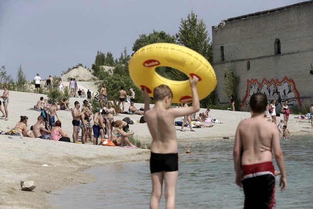 People sunbathe and swim in Murru prison, an abandoned Soviet prison, in Rummu quarry, Estonia, during hot weather July 4, 2015. (Photo by Ints Kalnins/Reuters)