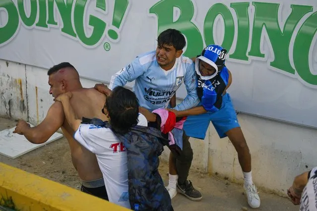 Fans clash during a Mexican soccer league match between the host Queretaro and Atlas from Guadalajara, at the Corregidora stadium, in Queretaro, Mexico, Saturday, March 5, 2022. Multiple people were injured during the brawl, including two critically. (Photo by Sergio Gonzalez/AP Photo)