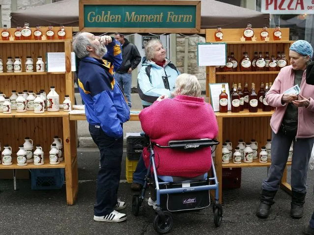 A couple samples the Maple Syrup produced by Golden Moment Farm at their stall during the Perth Maple Festival in Perth, Ontario, Canada, 26 April 2014. The annual maple syrup season marks the end of the often brutal central Canadian winters and heralds the beginning of spring. The maple tree, whose leaf dominates the Canada's flag, plays both a symbolic and practical role in the identity of Canadians who produce around 95 percent of the world's supply of maple syrup. (Photo by Stephen Morrison/EPA)