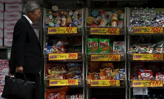 A man walks in front of price tags of items outside a discount store, at a business district in Tokyo, Japan, May 25, 2015. (Photo by Yuya Shino/Reuters)