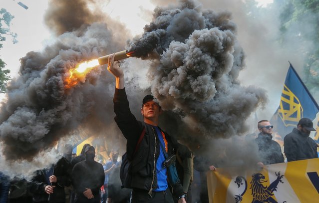 Members of volunteer's battalion “Azov” and their supporters from various right-wing movements burn smoke flares during a march in downtown Kiev, Ukraine, 20 May 2016. Activists demanded banning any elections on territory controlled by pro-Russian rebels until full observance of the Minsk agreements and protested against a draft law to give special status to the eastern regions locked in a conflict between the Ukrainian military and pro-Russian separatists. (Photo by Sergey Dolzhenko/EPA)