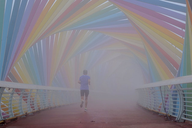 People work out in the Rainbow Bridge, which is shrouded in fog in the West Coast New Area, in Qingdao, Shandong province, China, on the morning of July 12, 2024. (Photo credit should read CFOTO/Future Publishing via Getty Images)