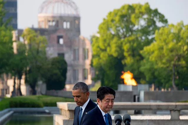 Japanese Prime Minister Shinzo Abe (front R) presents to speak after US President Barack Obama (L) made remarks after the two placed wreaths during a visit to the Hiroshima Peace Memorial Park in Hiroshima on May 27, 2016. Obama on May 27 paid moving tribute to victims of the world's first nuclear attack. (Photo by /AFP Photo)