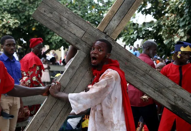A man performs as Jesus Christ during a procession marking the Good Friday in Abidjan, Ivory Coast, 15 April 2022. Christians in Ivory Coast joined their counterparts around the world to celebrate Good Friday, a ritual marked in commemoration of the crucifixion of Jesus Christ. (Photo by Legnan Koula/EPA/EFE)
