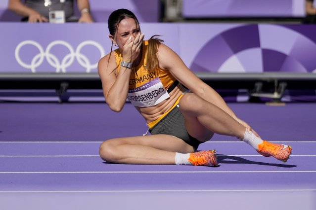 Sophie Weissenberg, of Germany, grabs her ankle after being injured while warming up for the women's heptathlon 100-meter hurdles at the 2024 Summer Olympics, Thursday, August 8, 2024, in Saint-Denis, France. (Photo by Ashley Landis/AP Photo)