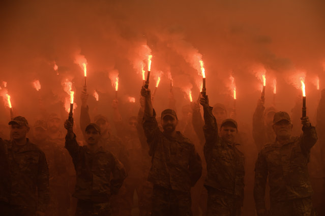 Servicemen of the Azov battalion are lighting flares as they attend a ceremony to remember the victims of the Olenivka camp explosion, in Kyiv, Ukraine, on July 28, 2024. (Photo by Maxym Marusenko/NurPhoto/Rex Features/Shutterstock)