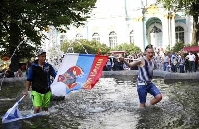 Russian men with flags stand in a fountain during celebrations of the Navy Day in St. Petersburg, Russia, July 26, 2015. (Photo by Reuters/Stringer)
