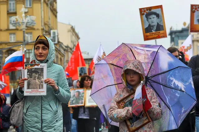 Participants carry portraits of people, including Red Army soldiers, during the Immortal Regiment march on Victory Day, which marks the 77th anniversary of the victory over Nazi Germany in World War Two, in Moscow, Russia on May 9, 2022. (Photo by Evgenia Novozhenina/Reuters)