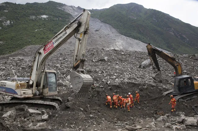Rescue workers search for victims of a landslide in Xinmo village in Maoxian County in southwestern China's Sichuan Province, Sunday, June 25, 2017. (Photo by Ng Han Guan/AP Photo)