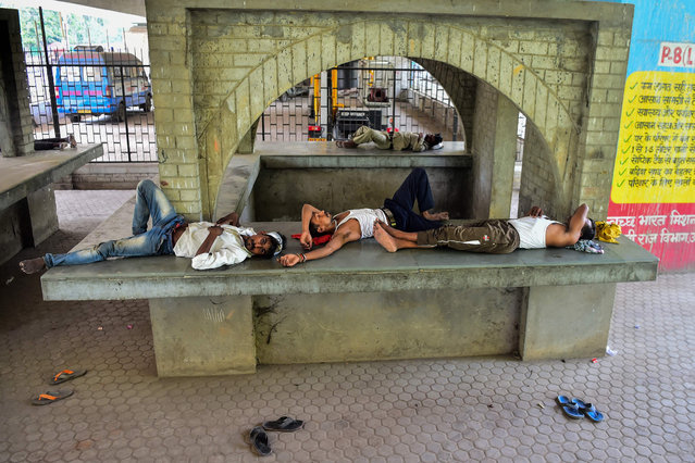 People rest under a bridge during a hot summer afternoon in Allahabad on May 14, 2022. (Photo by Sanjay Kanojia/AFP Photo)