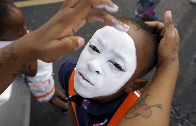 Keylah Pool, 8, has face paint applied before a protest march in Ferguson, Missouri August 8, 2015. One year after the police shooting of an unarmed black teen thrust Ferguson, into the national spotlight, the St. Louis suburb is bracing for a weekend of protests over continued complaints of police violence. (Photo by Rick Wilking/Reuters)
