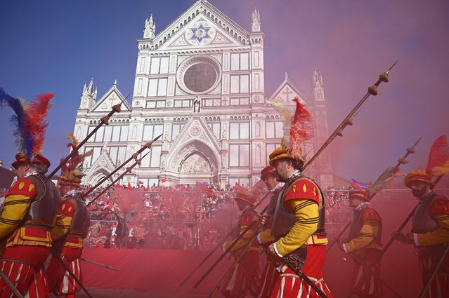 This photograph taken shows Florence's parade with traditional costumes prior to the Calcio Storico Fiorentino, a traditional 16th Century Renaissance ball game, at Piazza Santa Croce, in Florence on June 11, 2021. Calcio Fiorentino, an early form of football from the 16th century that originated from the ancient roman “harpastum”, is played in teams of 27, using both feet and hands and allows tactics such as head-butting, punching, elbowing, and choking, but forbids sucker-punching and kicks to the head. Goals can be scored by throwing the ball over a goal running the width of each end of the giant sand pit. (Photo by Vincenzo Pinto/AFP Photo)