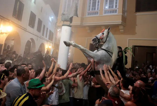 A rider rears up on his horse while surrounded by a cheering crowd during the traditional Fiesta of Sant Joan (Saint John) in downtown Ciutadella, on the island of Menorca, Spain June 23, 2016. (Photo by Enrique Calvo/Reuters)