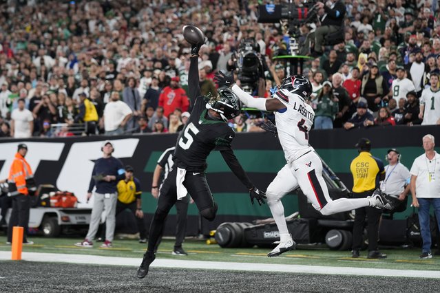 New York Jets wide receiver Garrett Wilson (5) catches a pass for a touchdown as Houston Texans cornerback Kamari Lassiter (4) defends during the second half of an NFL football game Thursday, October 31, 2024, in East Rutherford, N.J. (Photo by Seth Wenig/AP Photo)