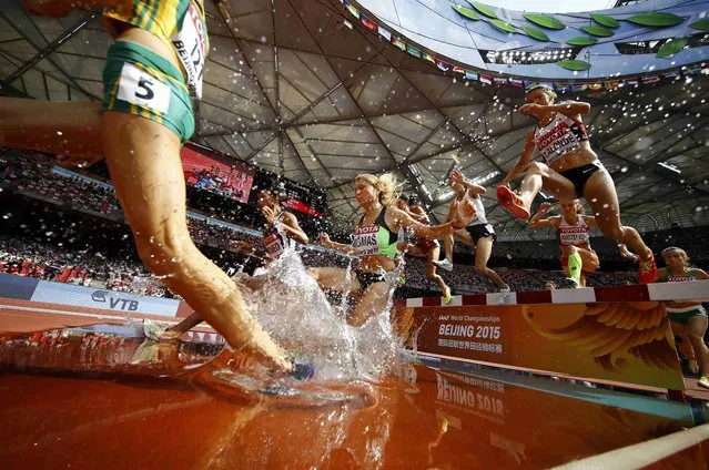 Athletes jump a water obstacle in the women's 3000 metres steeplechase final during the 15th IAAF World Championships at the National Stadium in Beijing, China August 24, 2015. (Photo by Kai Pfaffenbach/Reuters)