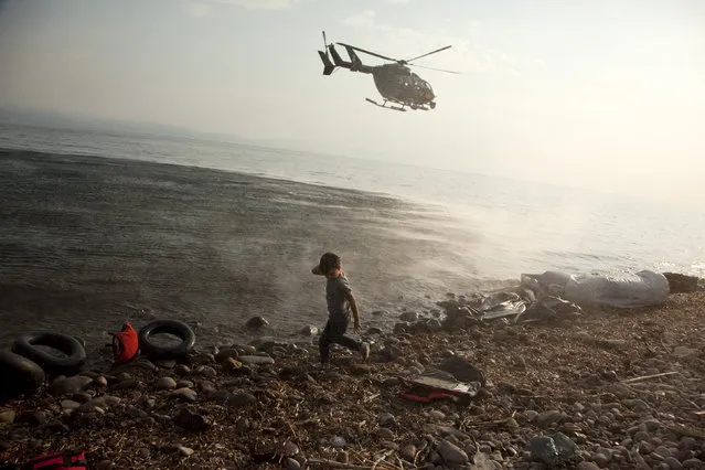 A Frontex helicopter patrols over a Syrian child that has just arrived at a beach at the Greek island of Lesbos August 10, 2015. Thousands of refugees and migrants are stranded on Greek islands – in some cases for over two weeks – waiting for temporary documents before continuing their travel to northern Europe. The United Nations refugee agency (UNHCR) called on Greece to take control of the “total chaos” on Mediterranean islands, where thousands of migrants have landed. About 124,000 have arrived this year by sea, many via Turkey, according to Vincent Cochetel, UNHCR director for Europe. (Photo by Antonis Pasvantis/Reuters)
