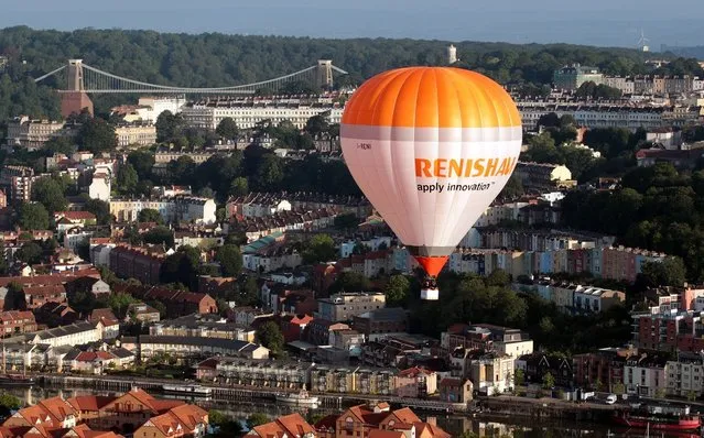 Hot air balloons take to the skies over Bristol city centre on August 6, 2012 in Bristol, England. The early morning flight of over twenty balloons over the city was organised as a curtain raiser for the four-day Bristol International Balloon Fiesta which starts on Thursday. Now in its 34th year, the Bristol International Balloon Fiesta is Europe's largest annual hot air balloon event in the city that is seen by many balloonists as the home of modern ballooning.  (Photo by Matt Cardy)