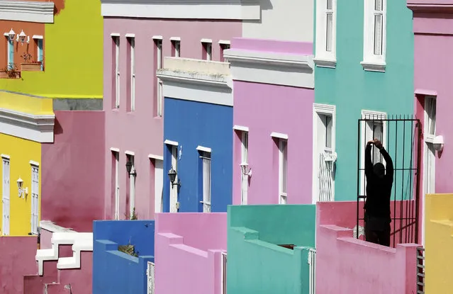 A man stretches, at the entrance of his home in Bo-Kaap, Cape Town, South Africa, Tuesday, April 7, 2020 as South Africa continued its 21 days lockdown in an effort to control the spread of the coronavirus. (Photo by Nardus Engelbrecht/AP Photo)