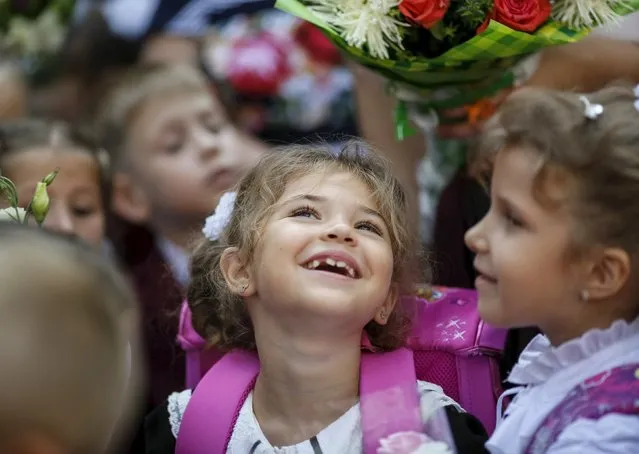 A first grader smiles as she attends a ceremony to mark the start of another school year in Kiev, Ukraine, September 1, 2015. (Photo by Gleb Garanich/Reuters)