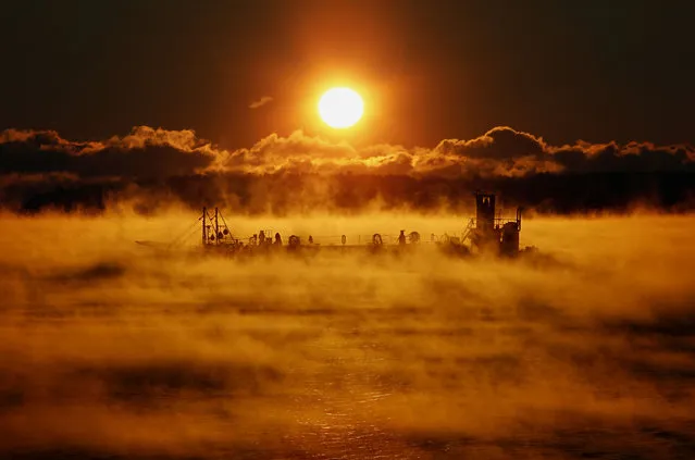 A barge motors through arctic sea-smoke on its way out of Portland Harbor, where the temperatures at sunrise was about minus 5 degrees Fahrenheit, Thursday, January 24, 2013, in Portland, Maine. (Photo by Robert F. Bukaty/AP Photo)