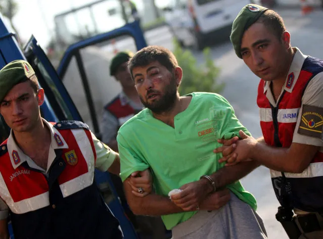 Turkish gendarmeries escort one of the 11 fugitive commandos who were involved in a bid to seize President Tayyip Erdogan during a failed coup attempt last month, as he arrives at the police headquarters in Mugla, Turkey, August 1, 2016. (Photo by Kenan Gurbuz/Reuters)