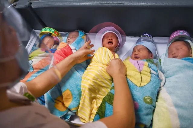 A nurse tends to a crying newborn baby wearing a face shield, as a preventive measure against the spread of the COVID-19 coronavirus, at the National Maternity Hospital in Hanoi, Vietnam on May 6, 2020. (Photo by Nhac Nguyen/AFP Photo)