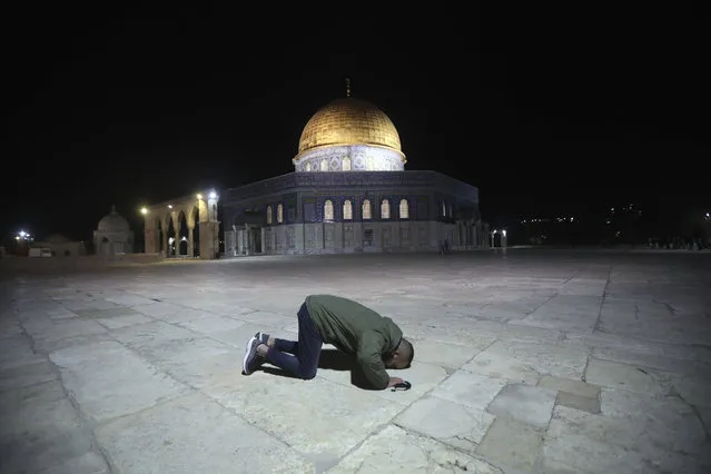 A muslim man pray next to the Dome of the Rock Mosque in the Al Aqsa Mosque compound in Jerusalem's old city, Sunday, May 31, 2020.The Al-Aqsa mosque in Jerusalem, the third holiest site in Islam, reopened early Sunday, following weeks of closure aimed at preventing the spread of the coronavirus. (Photo by Mahmoud Illean/AP Photo)