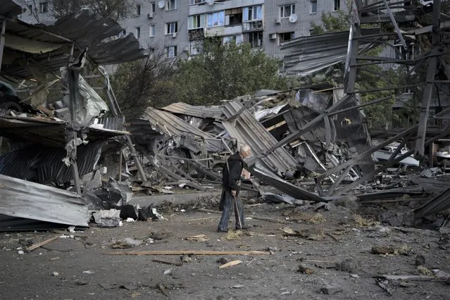 An elderly man walks past a car shop that was destroyed after a Russian attack in Zaporizhzhia, Ukraine, Tuesday, October 11, 2022. (Photo by Leo Correa/AP Photo)