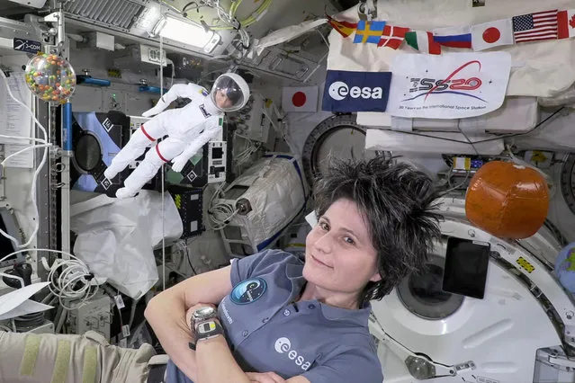 A handout picture shows Europe's first female commander of the ISS, ESA astronaut Samantha Cristoforetti with her lookalike Barbie doll at the International Space Station (ISS). (Photo by ESA/Handout via Reuters)