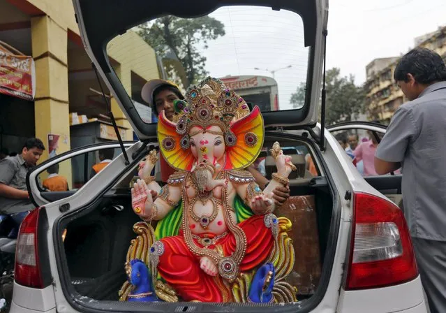 An idol of the Hindu god Ganesh, the deity of prosperity, is carried in a vehicle to a place of worship on the first day of the ten-day-long Ganesh Chaturthi festival in Mumbai, India, September 17, 2015. (Photo by Shailesh Andrade/Reuters)